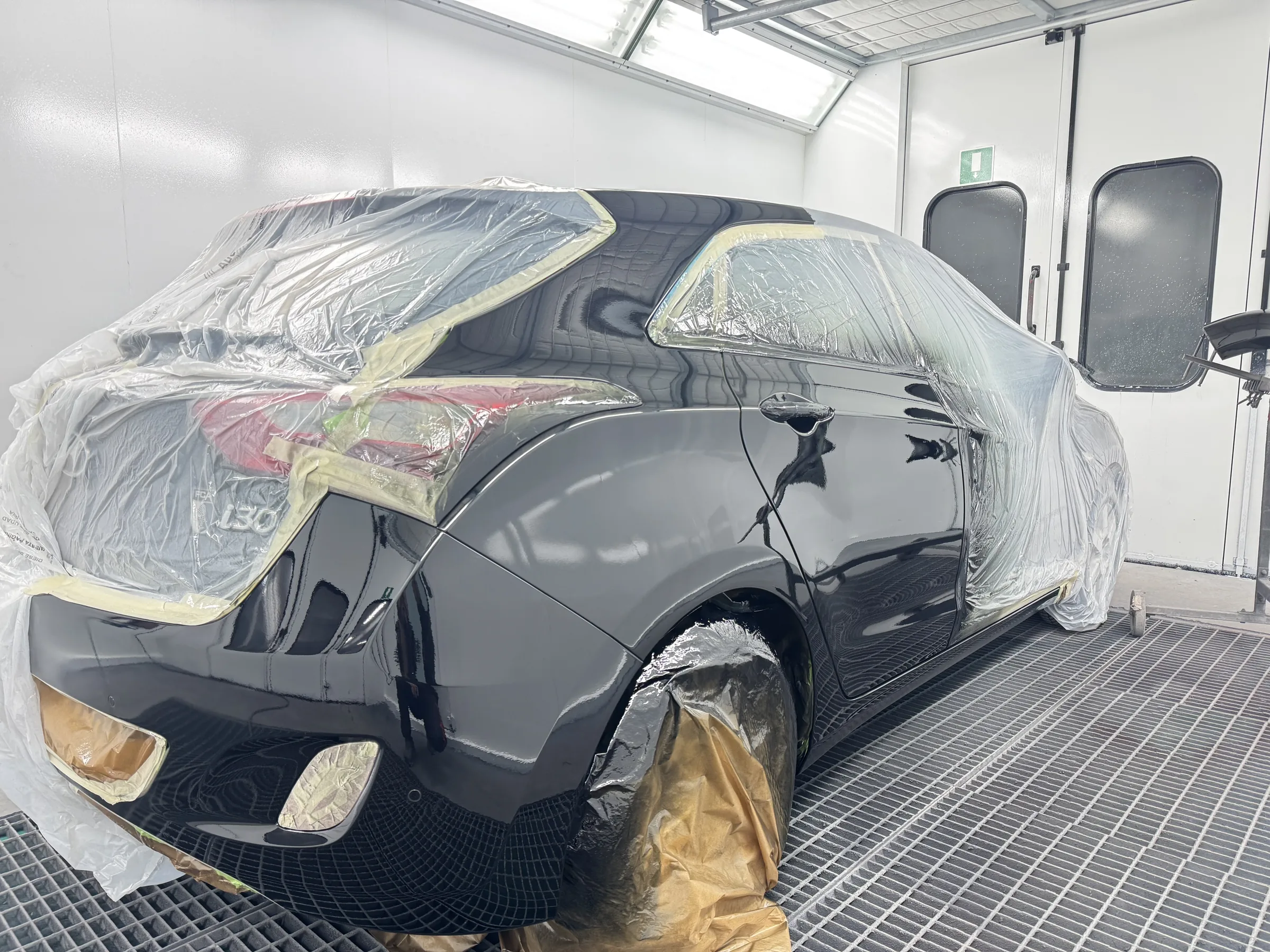 Schwarzes Fahrzeug abgeklebt in der Lackierkabine – Cataldo Augsburg